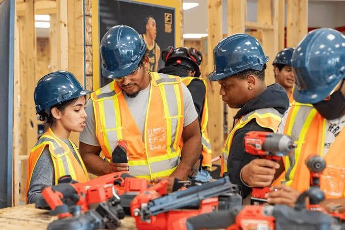 Construction workers in PPE collaborating on site