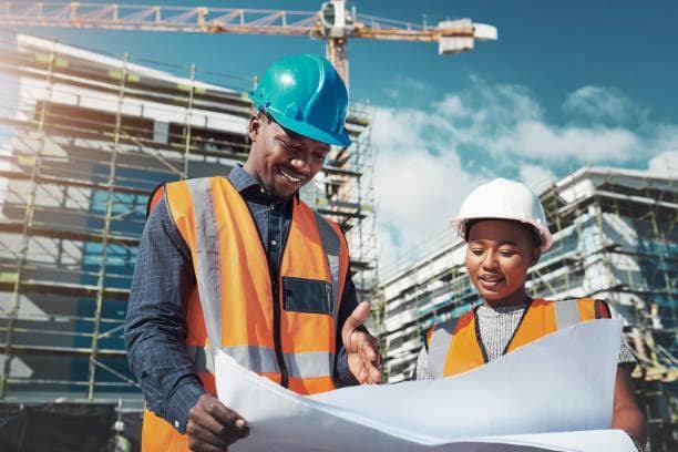 Construction professionals reviewing plans at a job site